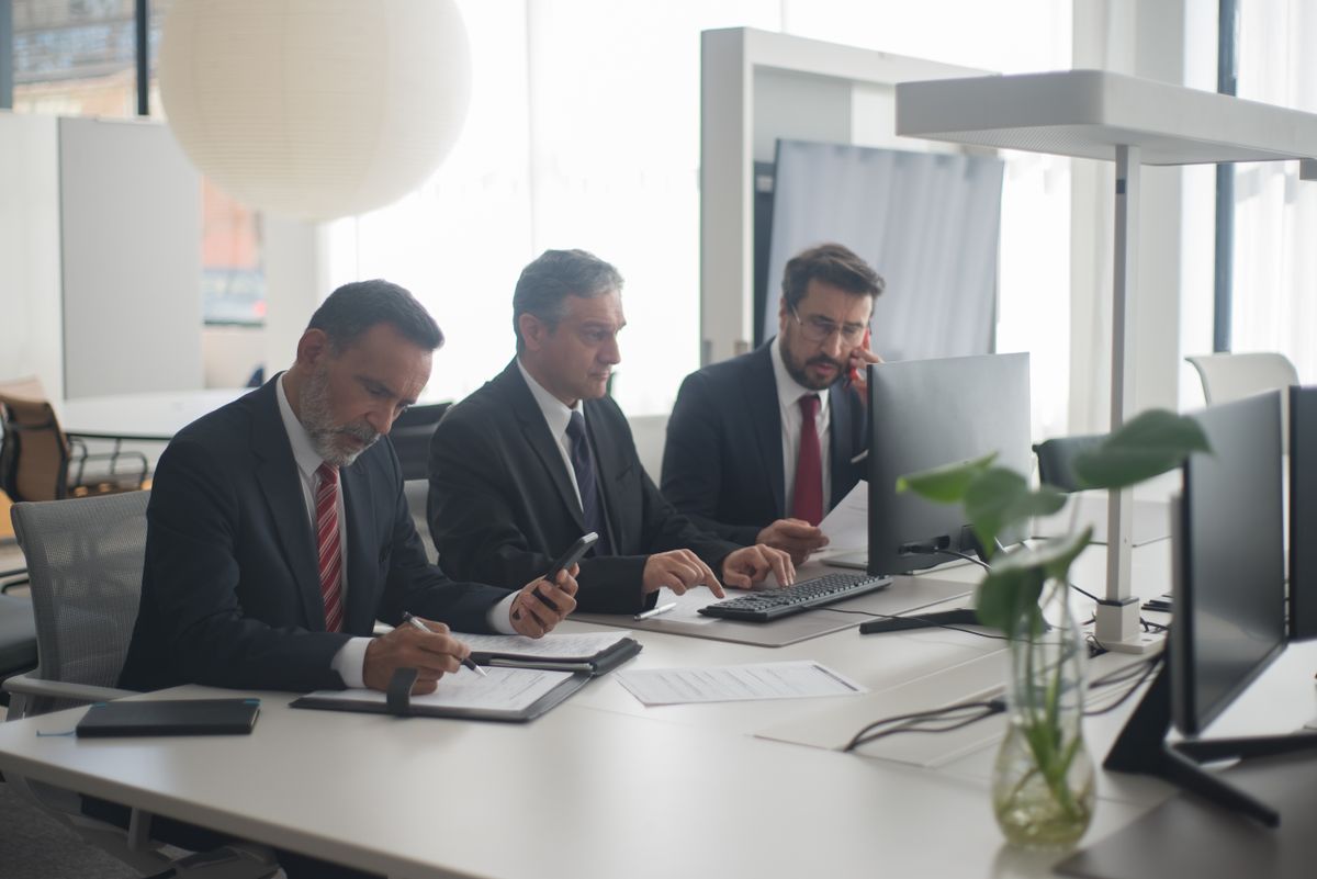 Bank advisers reviewing customer product options together at a branch desk