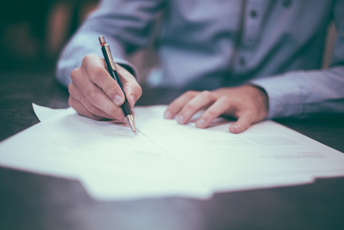 Auditor cross-checking system access policies against a printed compliance checklist at a desk