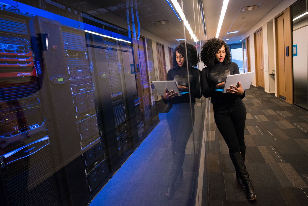 Infrastructure engineer checking a rack layout on a tablet while commissioning new server hardware