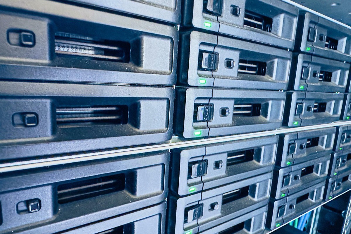 An engineer sliding a drive into a server rack, the hands-on upkeep that continues after a platform goes live