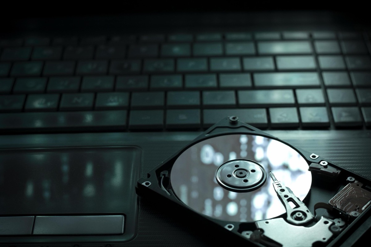 Opened hard drive resting on a laptop keyboard