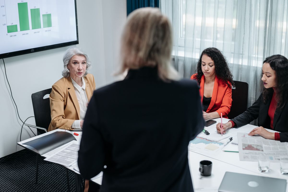 HR specialists reviewing employee records and headcount reporting together in a meeting room
