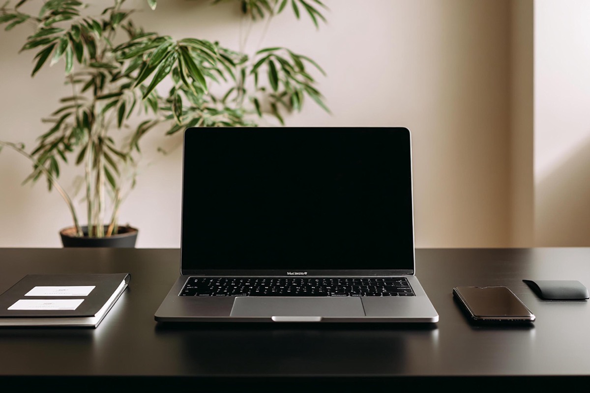 Open laptop and notebook on a tidy office desk