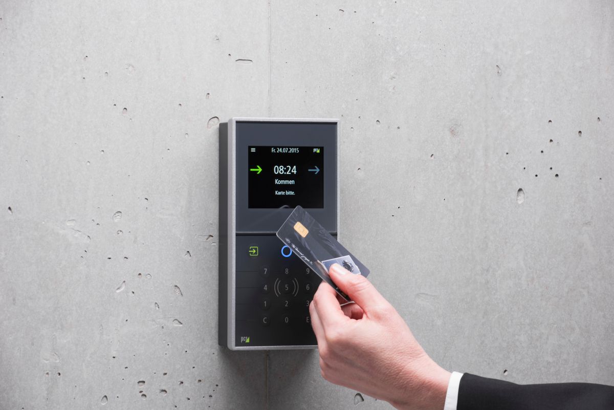 Employee presenting an access card to a wall-mounted network access control reader at a secured entry